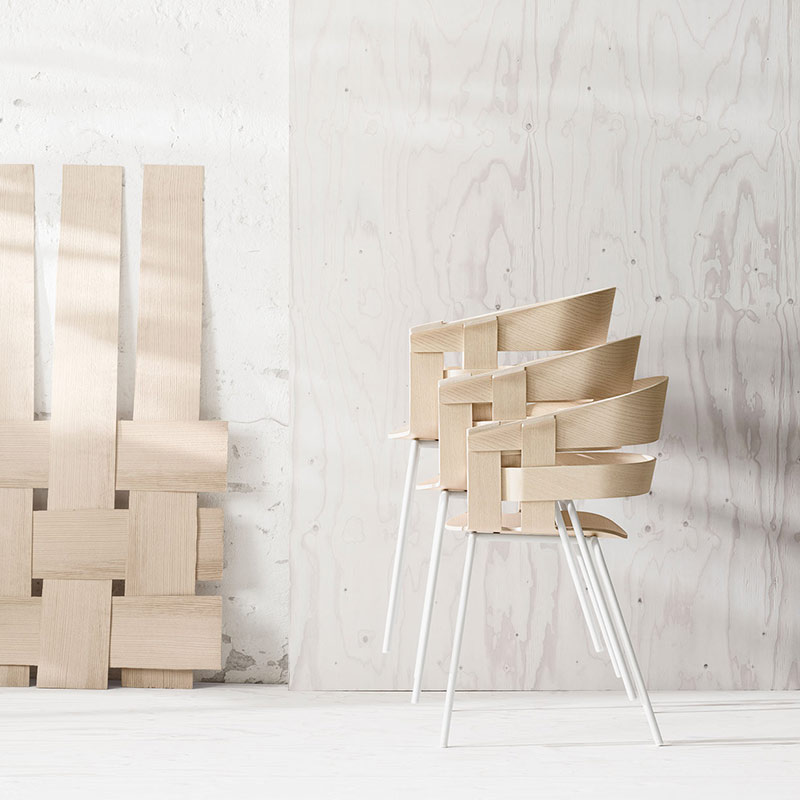 A chair made out of cardboard boxes sitting in front of a wall.