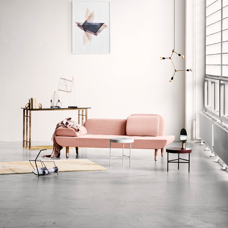 A living room with a pink couch and table