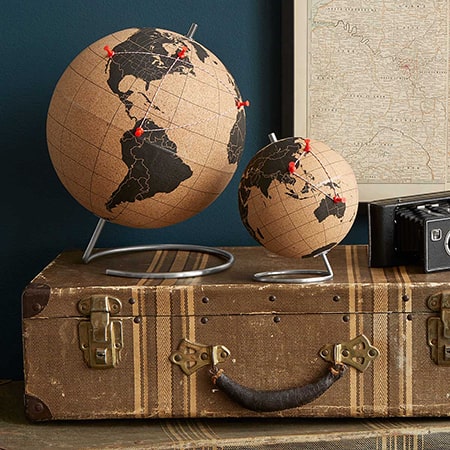 Two globes on a suitcase with a map in the background.