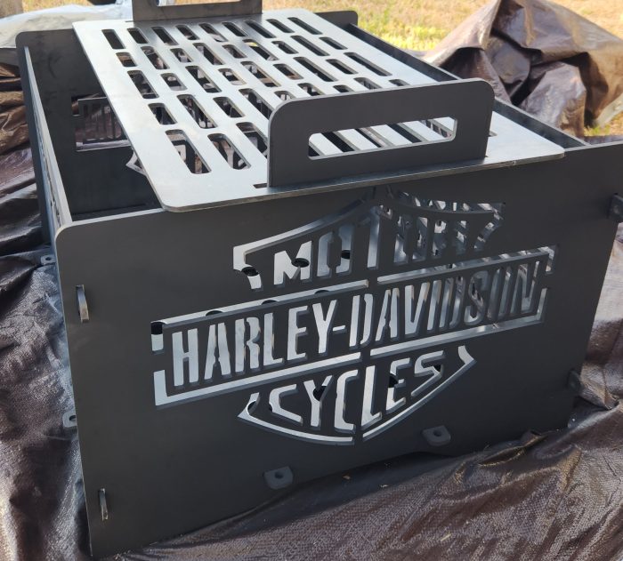 A harley davidson grill sitting on top of the ground.
