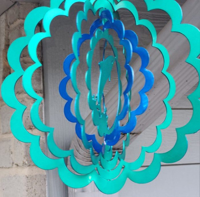 A blue and green wind spinner hanging from the ceiling.