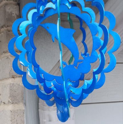 A blue wind spinner with a dolphin on it.