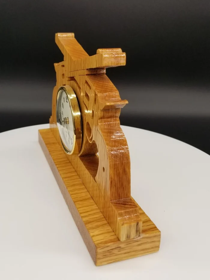 A wooden clock with a gold face sitting on top of a table.