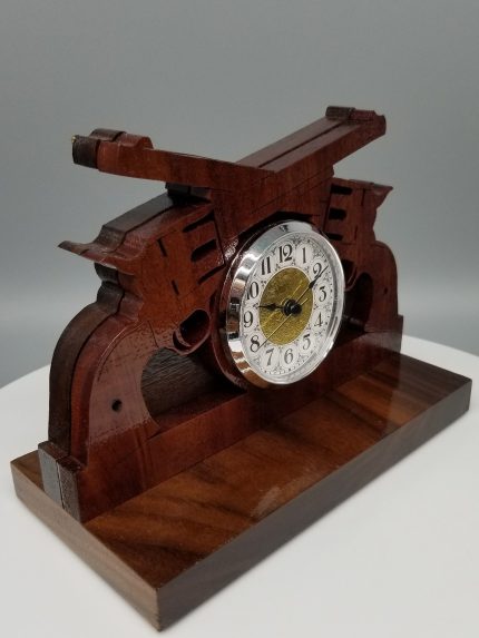 A wooden clock with a metal face on top of it.