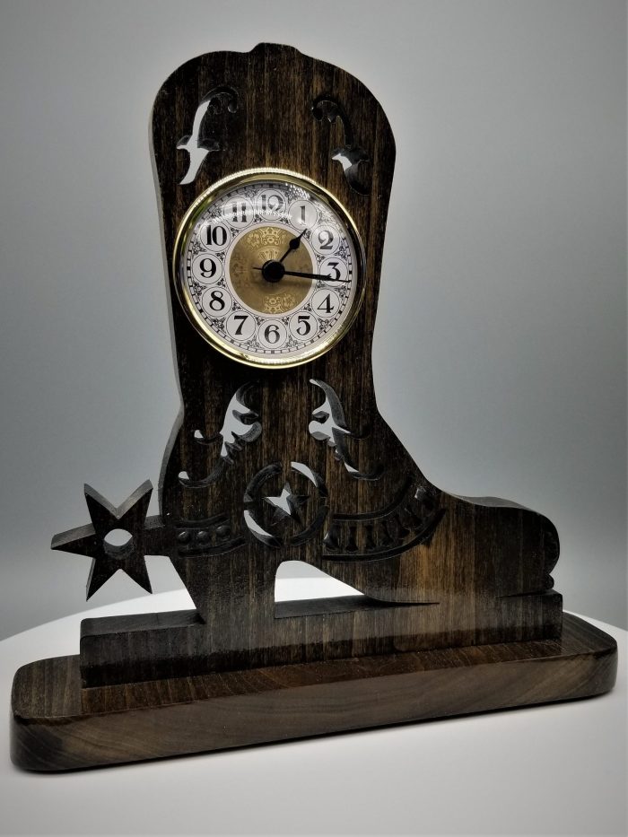 A wooden clock with a cowboy boot on top of it.