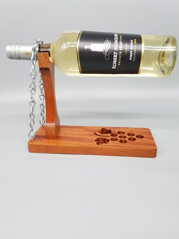 A bottle of wine is attached to the side of a wooden stand.