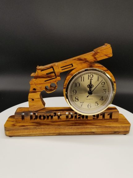A wooden clock with a gun on it