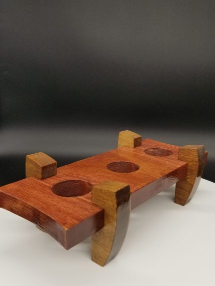 A wooden object with three holes in it.
