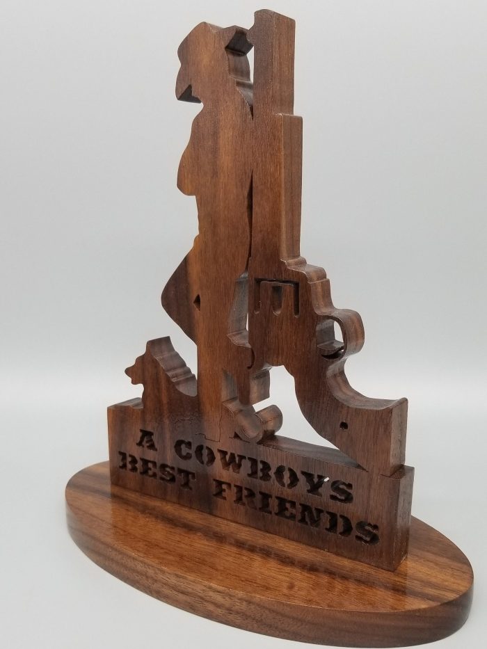A wooden statue of a cowboy and his dog.