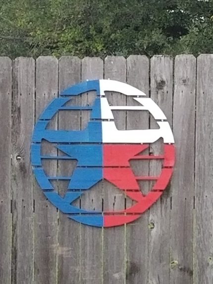 A wooden sign with the texas state flag painted on it.