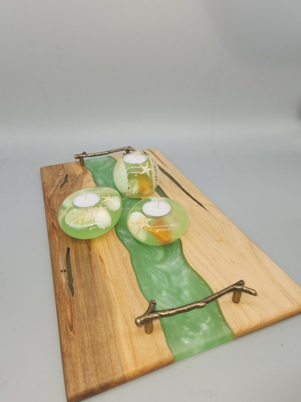 A wooden tray with green glass on top.
