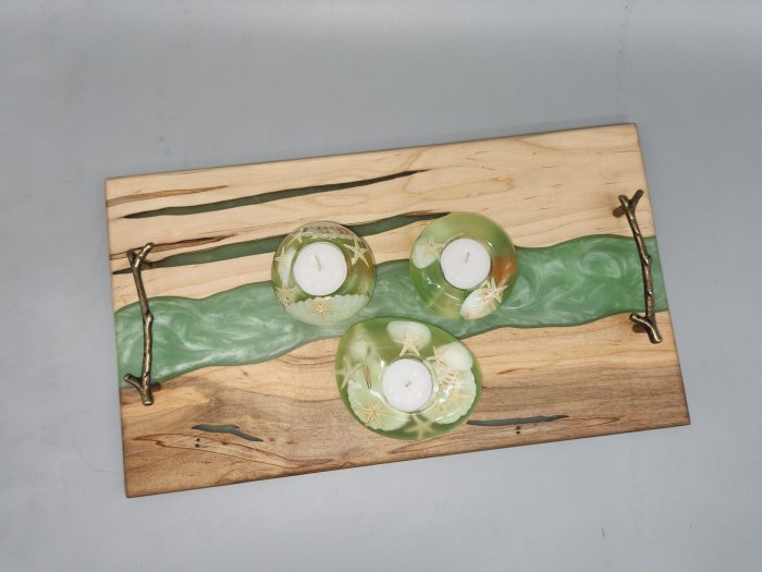 A wooden tray with three candles on top of it.