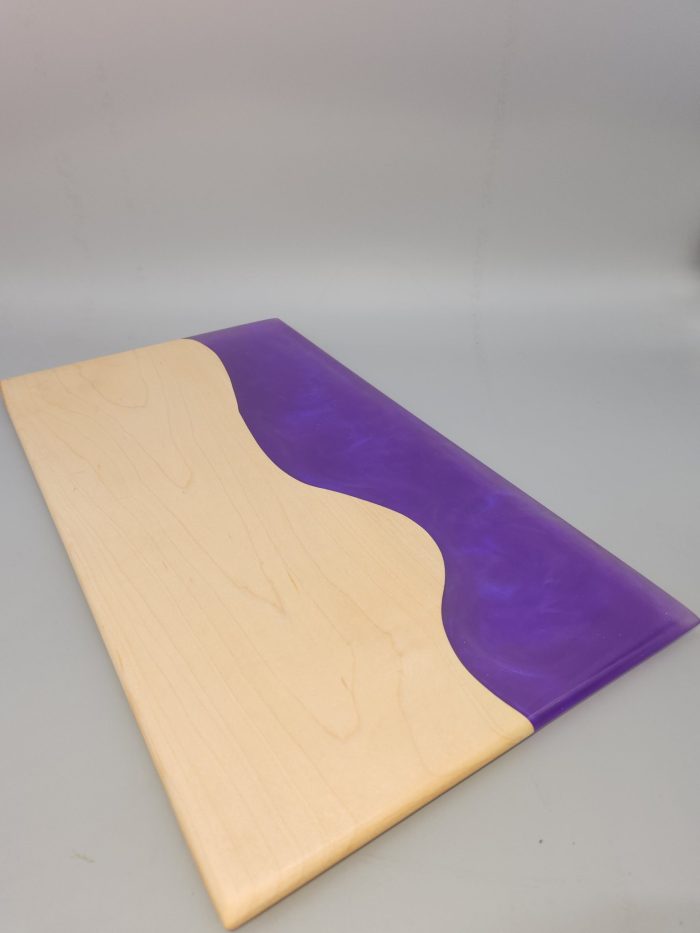 A purple and white wooden board with a wave design.