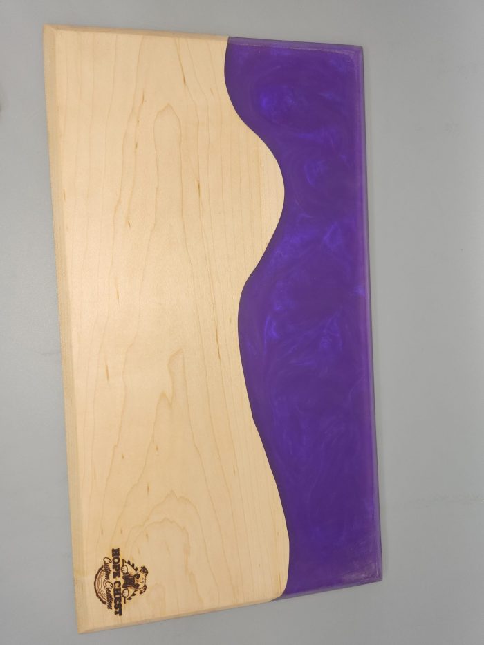 A skateboard with purple and white wood on it.