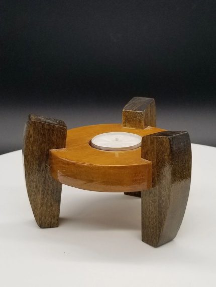 A candle holder made of wood with a candle inside.