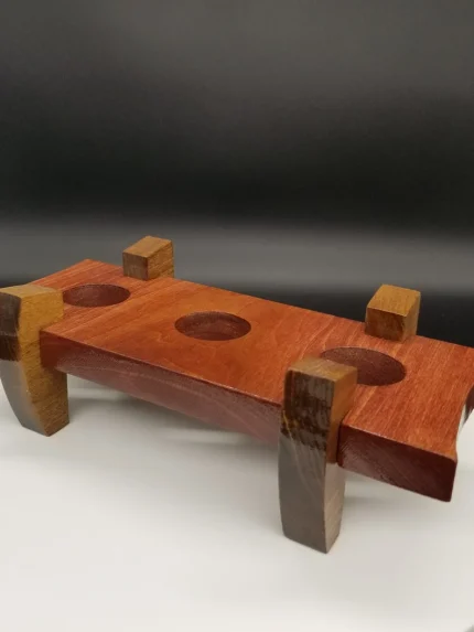 A wooden object with two blocks and three holes.