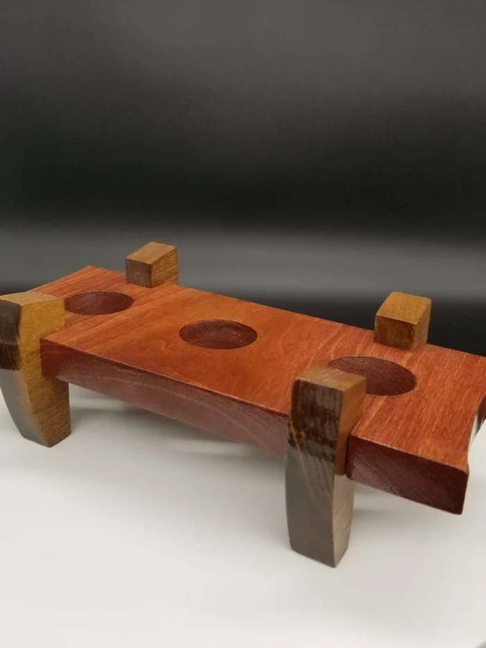 A wooden object with two blocks and three holes.