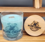 A candle and wooden lid on top of a shelf.