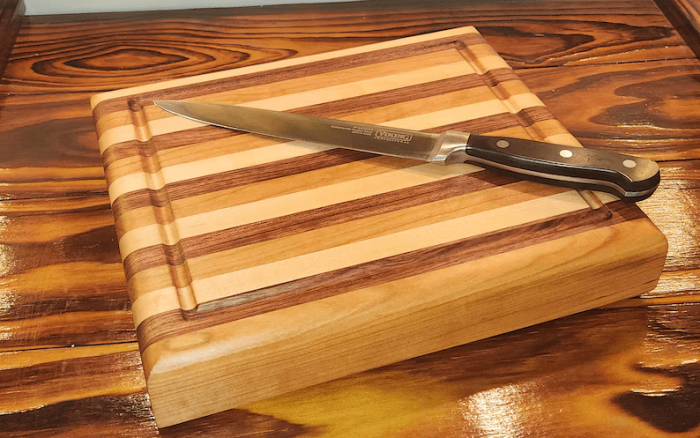 A cutting board with a knife on top of it.