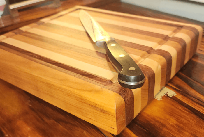 A knife on top of a cutting board.