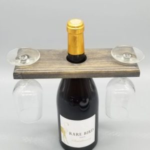 A wine bottle holder with two glasses and a cork.