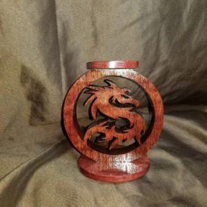 A wooden dragon candle holder sitting on top of a table.