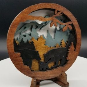 A wooden picture of bears and mountains