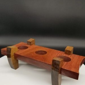 A wooden object with two legs and three holes.