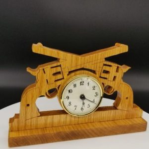 A wooden clock with guns on it