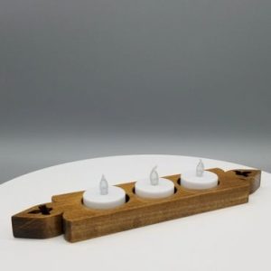 A wooden candle holder with three candles on top of it.