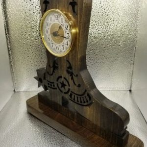 A clock is sitting on top of a wooden stand.