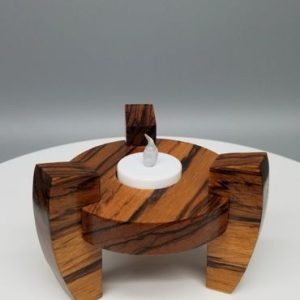 A wooden candle holder with a white candle.