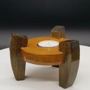 A wooden candle holder with a candle inside of it.