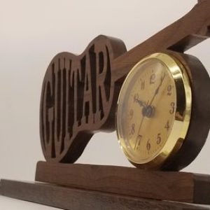 A wooden clock with the word guitar on it.